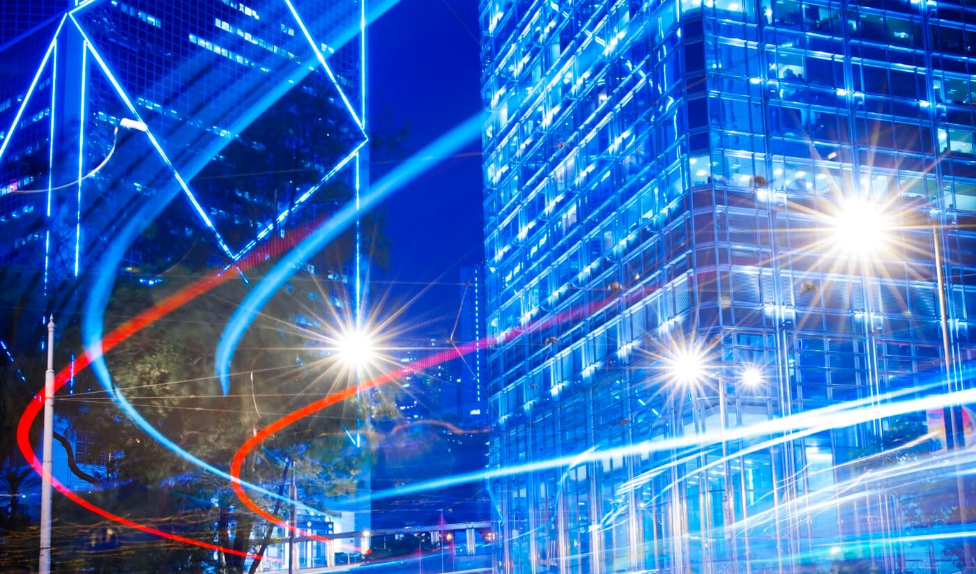 Connected city infrastructure with data flowing between buildings representing scalable network deployment