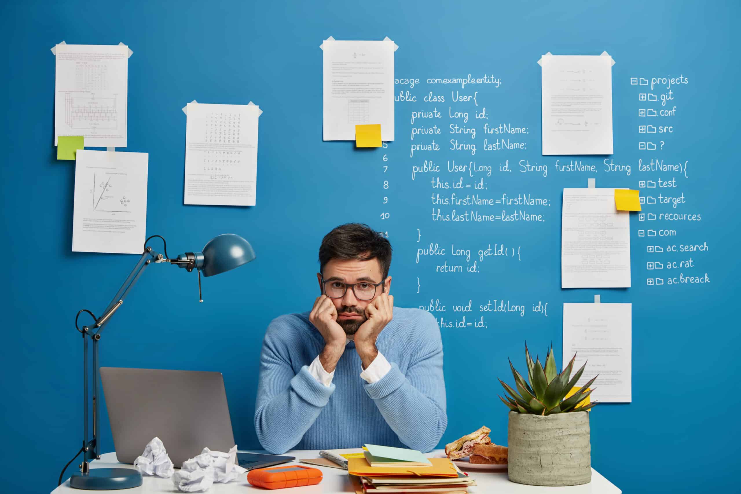 Engineer waiting at desk for slow manual device configuration deployment